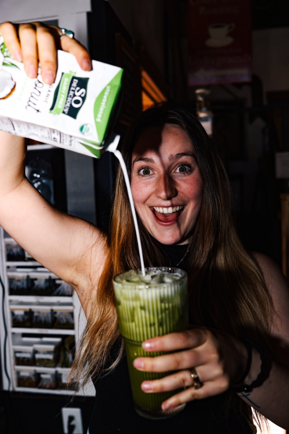 A Charro's barista pouring milk into an iced matcha latte