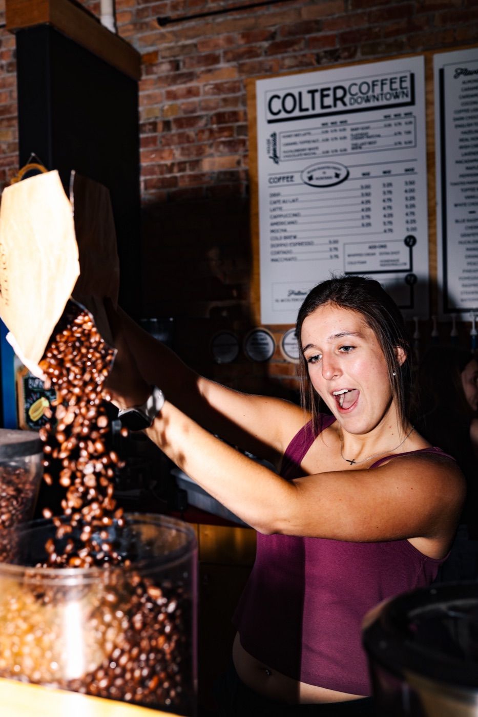 A Charro's barista filling the grinder hopper with fresh beans