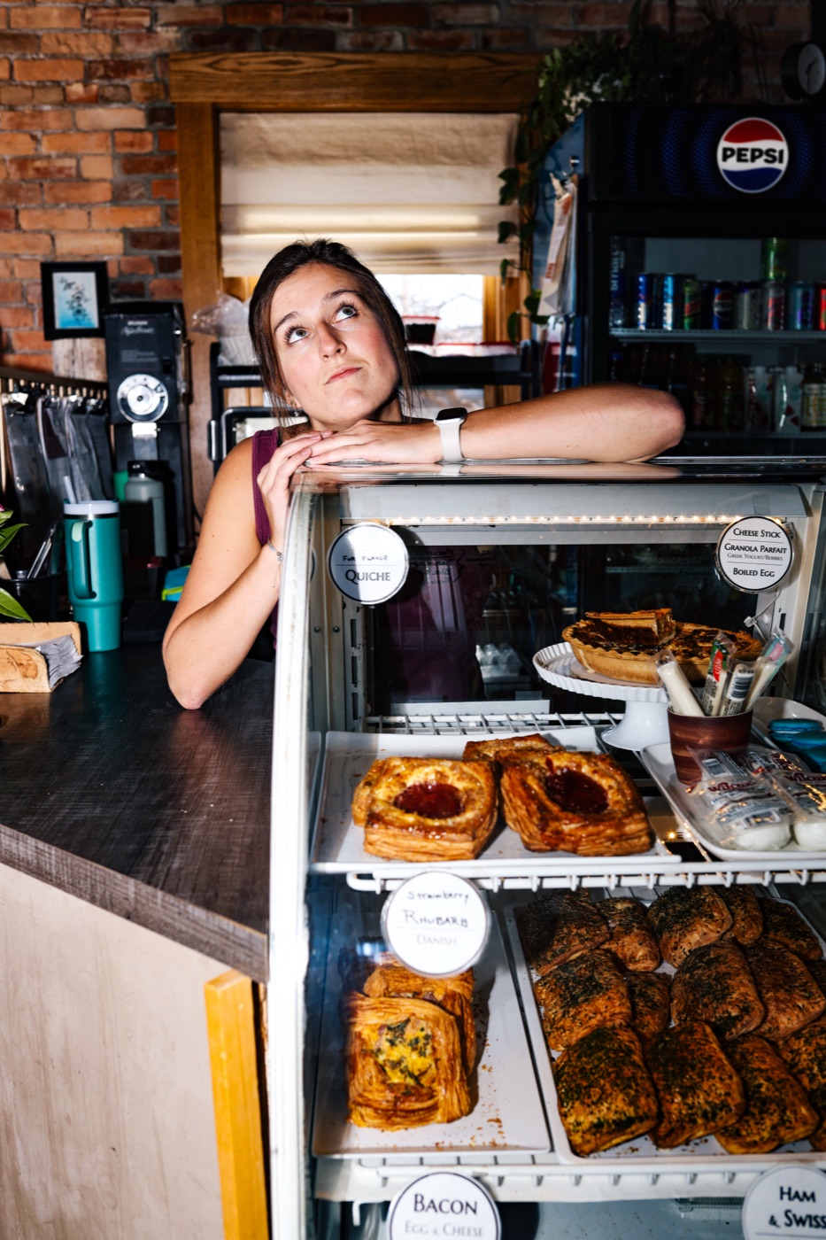 A Charro's barista leaning over the pastry case behind the counter